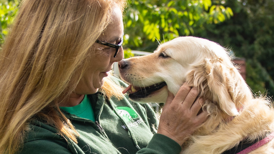 Sue Ketland embracing golden retriever